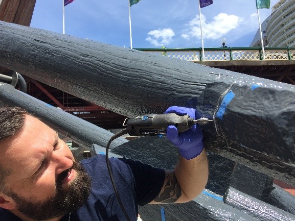 Jeff Fox removing paint from the Seafarers’ Memorial Anchors. Image by L. Ronai.