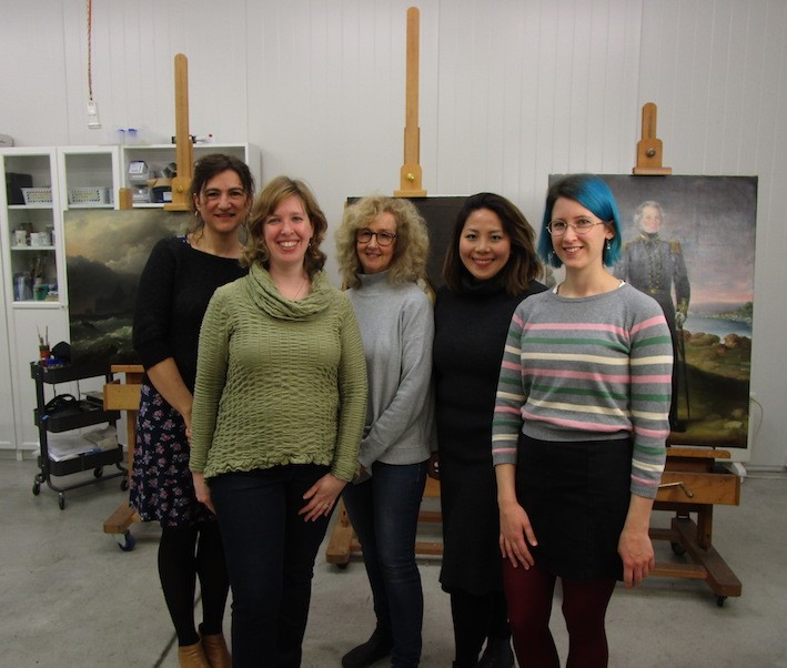 Conservator Felicity Corkhill studio visit, with our conservators and the State Library paintings in the background.