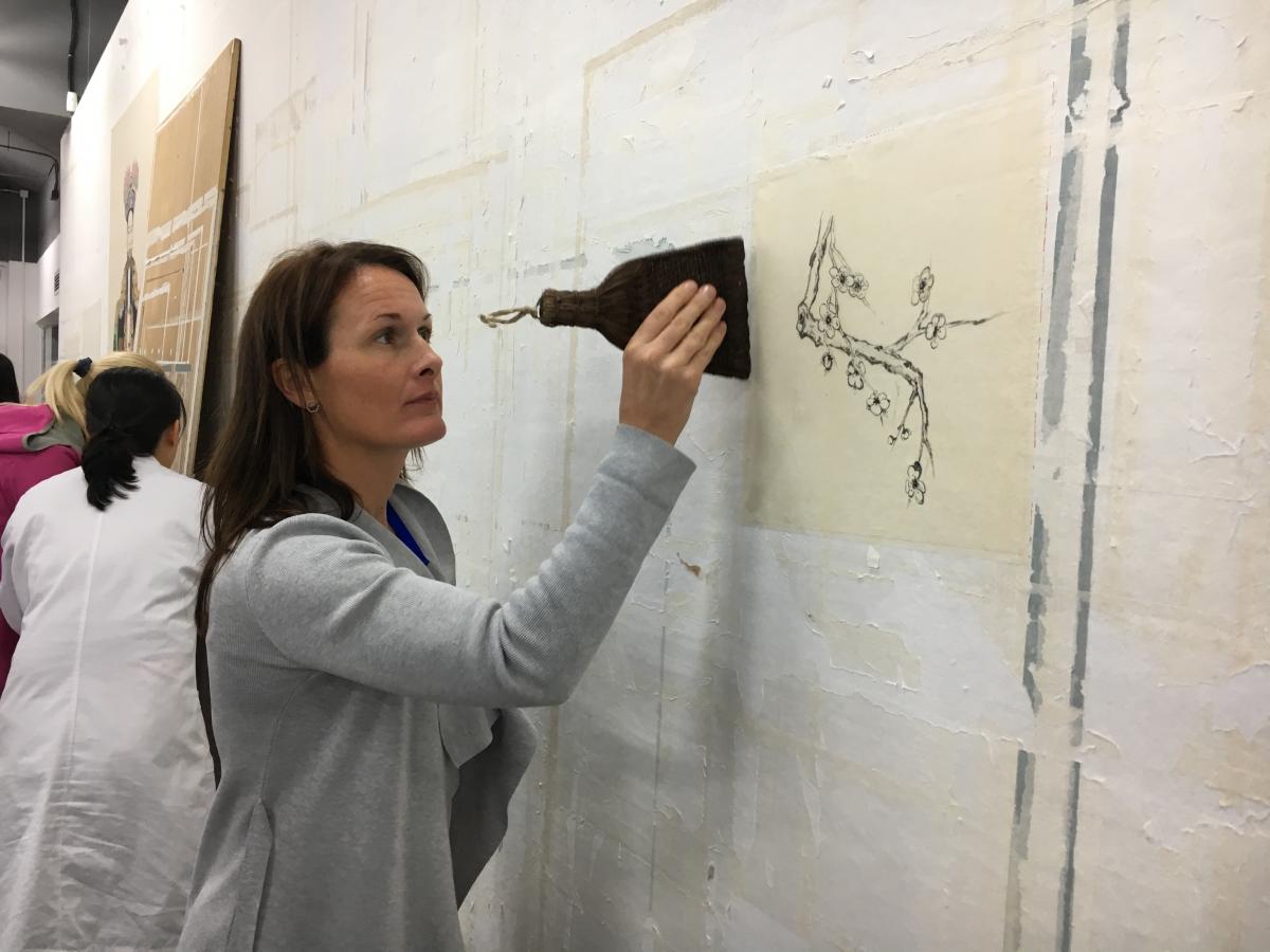 Analiese Treacy attaching a Chinese watercolour painting onto the largest Karibari board in China