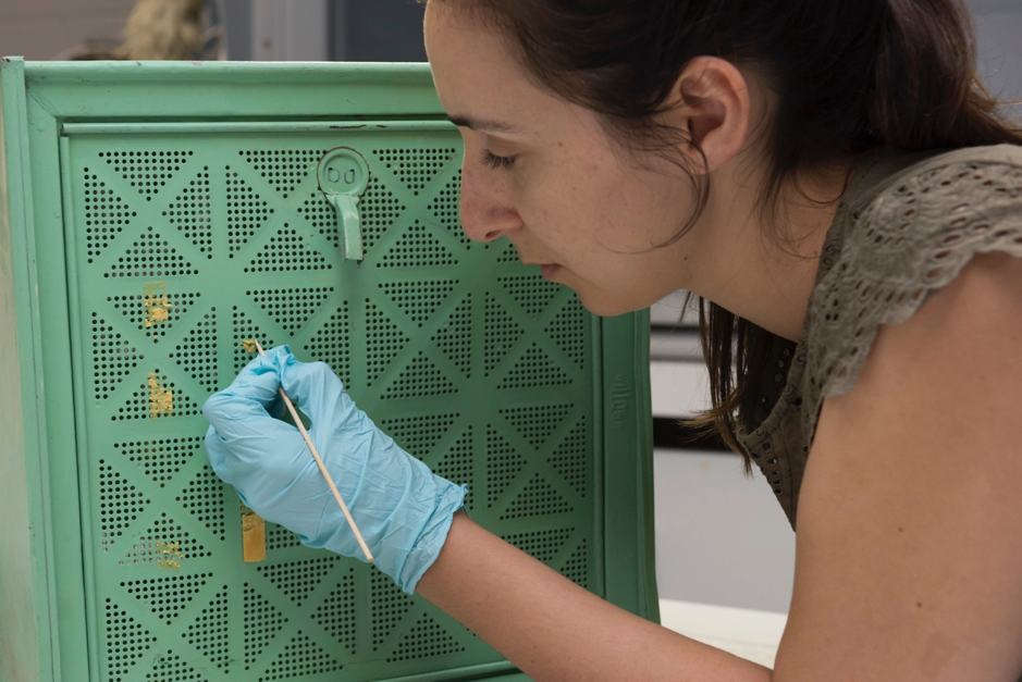  E Urrutia-Bernard removing adhesive residue, photo by M.Campbell