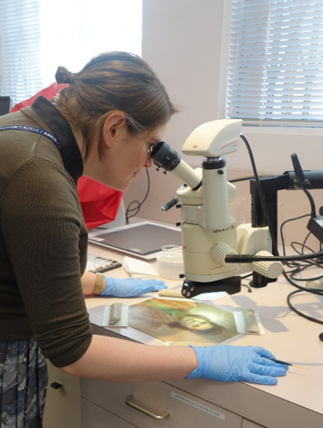 Kate Hughes examining area of photograph to be retouched