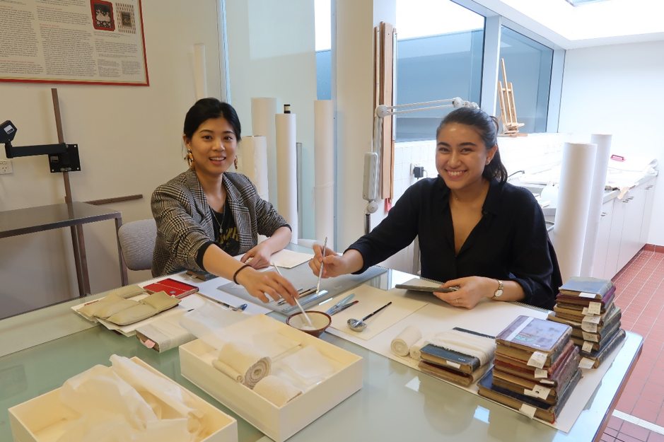 Interns Karolin Wu and Isabella Ling carrying out treatments in preparation for display of artwork Chinese Bible