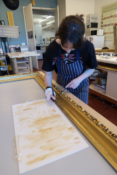 Conservator working on frame in conservation lab