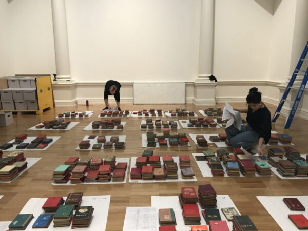 Conservators working on floor surrounded by stacks of books