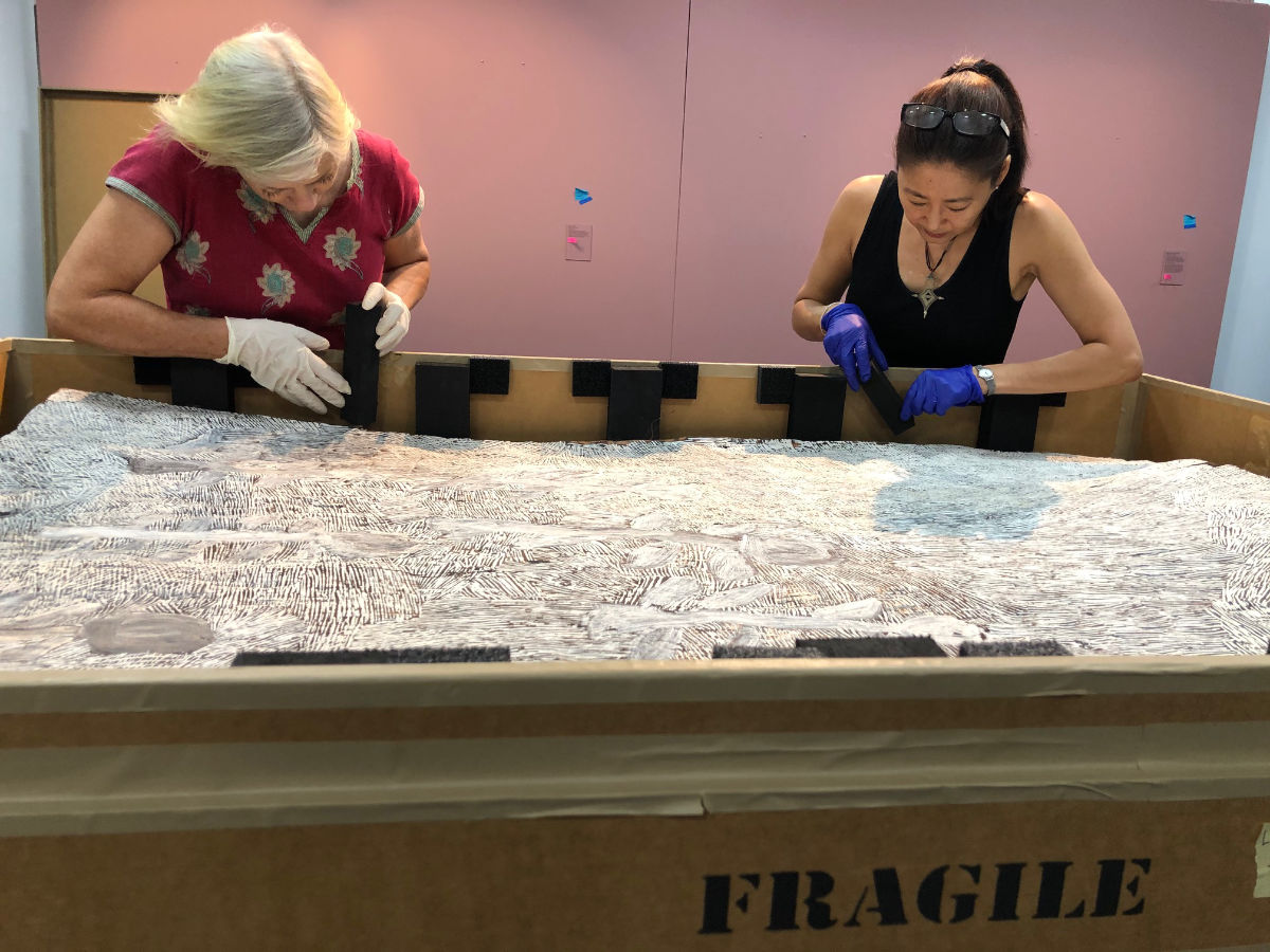 Image of Fiona Bennie and Sandra Yee refitting the final bark-painting box. 