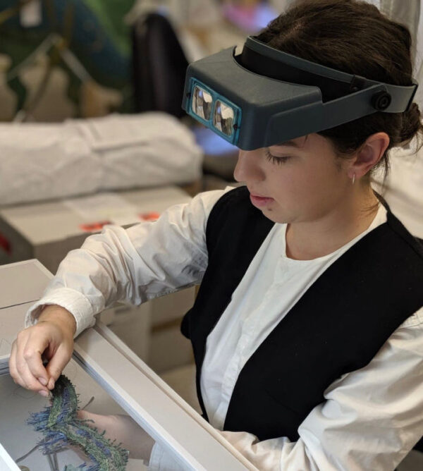 Young conservator working on a textile piece