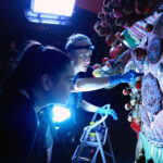 Conservators working with temporary lights on a treatment of a imperial processional dragon