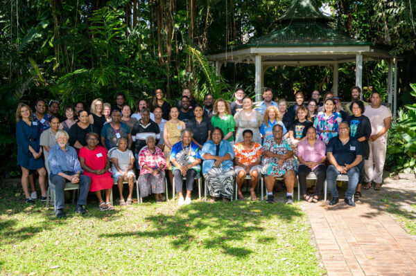 IACA conference participants: large group of conference participants sitting in a sunny outdoors setting