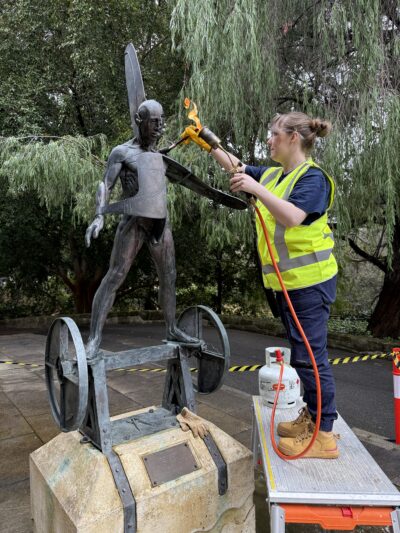 Claire and Lorna undertaking conservation of the bronze and concrete sculpture Homo Fallible .  